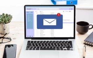 A laptop featuring an email marketing icon on a desk.