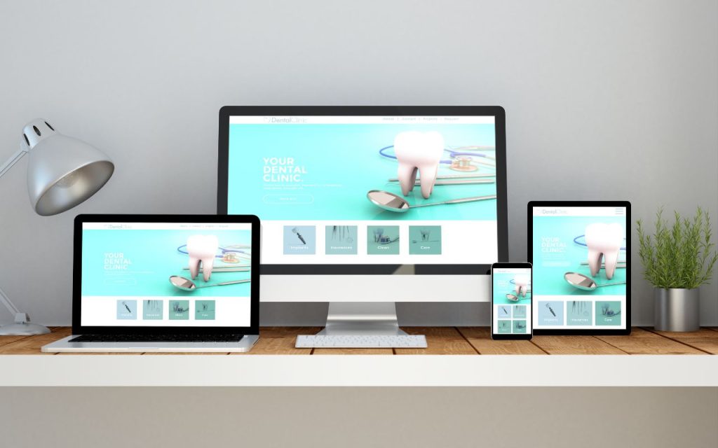 AI Overviews - to show up in AI search results, your website needs the right structure. A desktop, laptop, tablet, and smartphone on a desk all display the same dental clinic website with a large tooth graphic on a blue background.